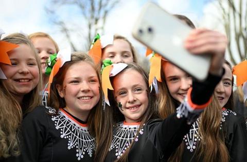 girls taking a selfie at a st Patrick's Day parade