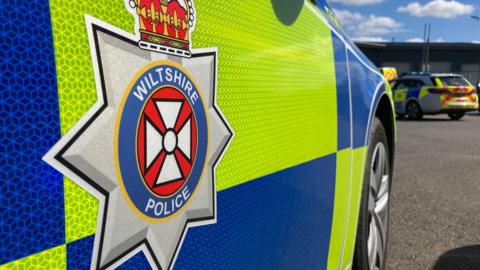 Generic close-up shot of the side of a Wiltshire Police car showing the logo