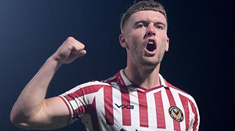 Cameron Evans celebrates after Newport County's penalty shoot-out win at Barnet