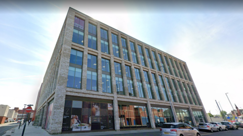 Image shows one of two Birkenhead office blocks leased by Wirral Council. It is a five-storey building clad in grey brick. 