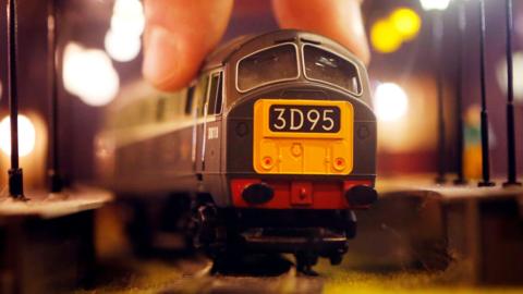 The front of a Hornby Class 29 model train with a yellow panel and 3D95 written on the front. A finger and thumb are on the top of the train