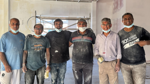 Six men in paint-splattered clothes