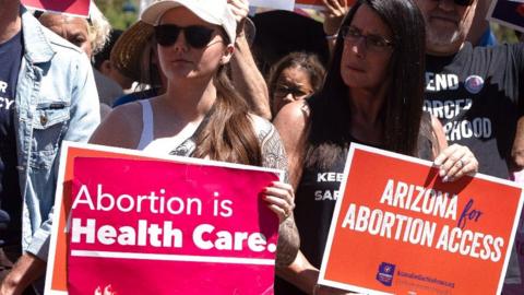 Two female protesters hold up pro-choice signs