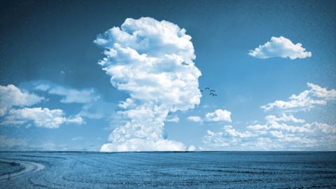 Clouds forming the shape of a head above a field