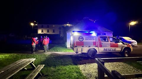 A cave rescue vehicle on blue lights at night park outside Matlock Mining Museum