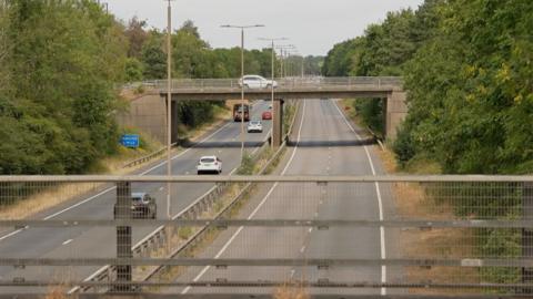 A view of the A38 carriageway from a bridge.