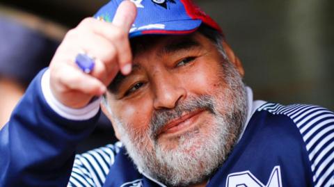 Diego Maradona gives a thumbs up during a football match in 2019.