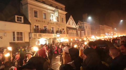 Crowds in fancy dress and carrying burning torches fill the streets of Lewes in its annual bonfire procession in 2022.