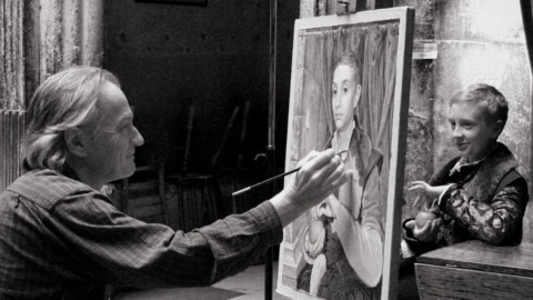 A black and white image of Michael Taylor painting Boy With Apple. Young Ed Munro is modelling for him.