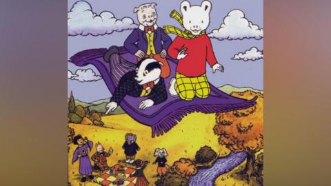 A cartoon drawing of a white bear, dressed in a red jumper and checked yellow scarf and trousers. He is on a purple flying carpet with a badger, dressed in a checked black suit, yellow shirt and red bow tie. There is also a pig, dressed in a blue suit, yellow shirt and red bow tie and trousers. Beneath them are andromorphic animals and a girl waving at them.