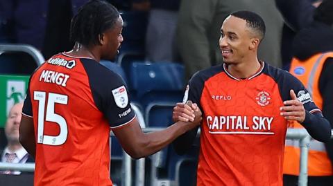 Corey Bramall shakes hands with team-mate Teden Mengi following his goal against Port Vale