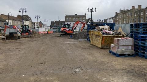 St Neots Market Square being razed by diggers, with all the paving taken up and skips full of waste