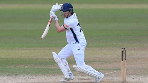 Left-handed Hampshire opener Ali Orr plays off-drive, wearing whits and Hampshire blue club helmet.