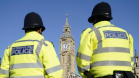 File photo dated 19/03/22 of the Elizabeth Tower, part of the Palace of Westminster, is seen between two Metropolitan Police officers in Parliament Square, London.