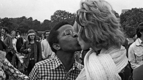 An interracial couple kissing at the UK's first pride