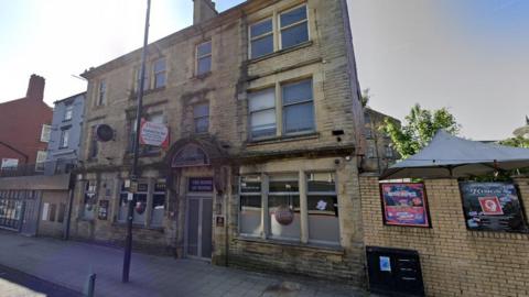 A three-storey former nightclub. The brick-built building has a for sale sign on the front.