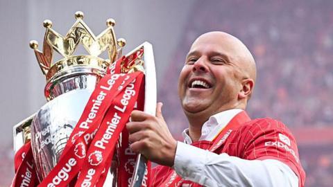Liverpool manager Arne Slot lifting the Premier League trophy