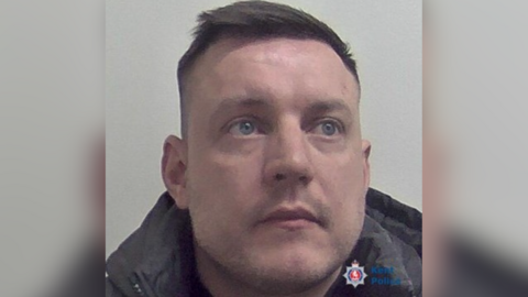 Mugshot of Jamie Stacey-Evans provided by Kent Police. Stacey-Evans looks off to the left-hand-side of the camera and has been positioned against a light grey background.