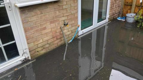 Flooded garden, knee deep at the property doors