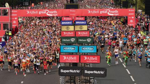 thousands of runners setting off from the starting line.