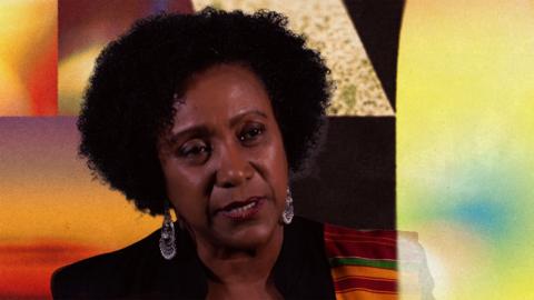 Woman with natural afro hair and silver earrings against a colorful abstract backdrop