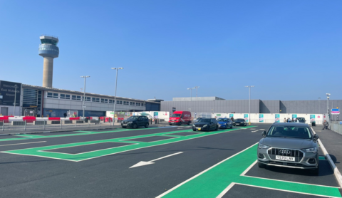 A car park at the airport with the air traffic control tower in the background