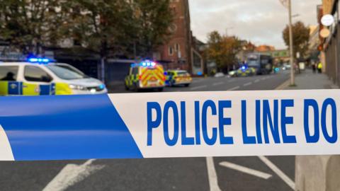 A police car parked next to police tape in Nottingham city centre