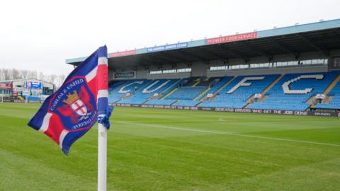 A view of Carlisle's Brunton Park from the corner flag with 'CUFC' on blue seats