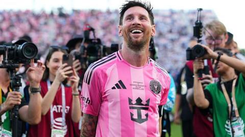 Lionel Messi smiles while cameras are focused on him