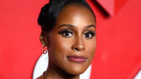 Issa Rae head shot, she is looking fairly serious and is staring straight ahead