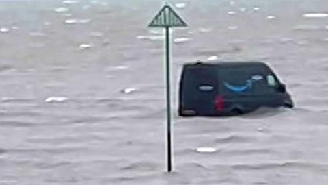 Dark van cut off from the shore with sea water surrounding it