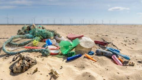 plastic items lying on a beach. 