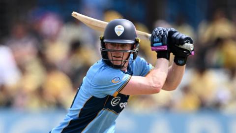 Right-handed Brooke Guest plays a shot through the covers in blue Derbyshire kit