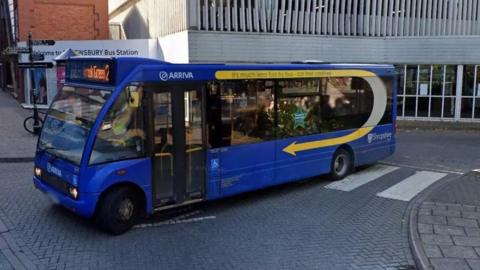 A blue bus parked on a road