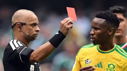 Brazilian referee Wilton Sampaio shows a red card to South Africa's midfielder #11 Themba Zwane