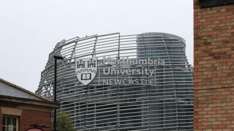 Image of Northumbria University sign and logo on white ribbed futuristic looking building