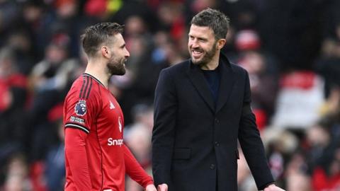 Manchester United head coach Michael Carrick enjoys a smile with defender Luke Shaw