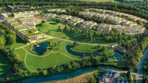 A CGI image of white buildings in a curved arrangement on green land surrounded by trees, with a river in the foreground