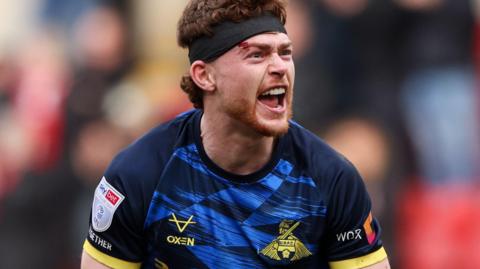 Doncaster defender Jack Senior shouts and poses in celebration after a win