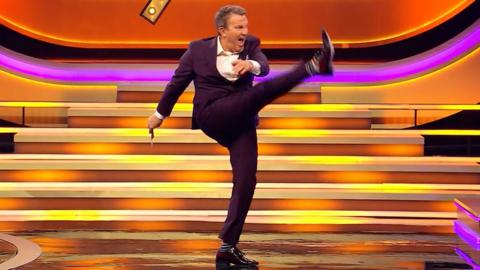 Bradley Walsh shouting and kicking the air on the set of Blankety Blank