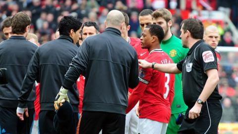 Patrice Evra (red shirt) and Luis Suarez (second left, black top) at Old Trafford in February 2012
