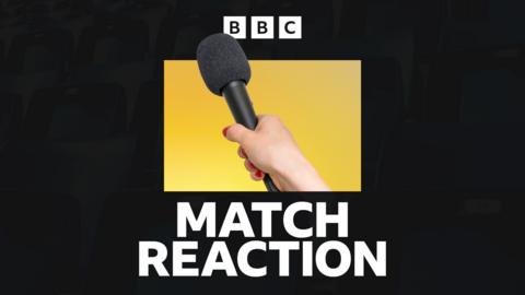 A hand holding a microphone, in front of a yellow and black background and above the words 'match reaction'