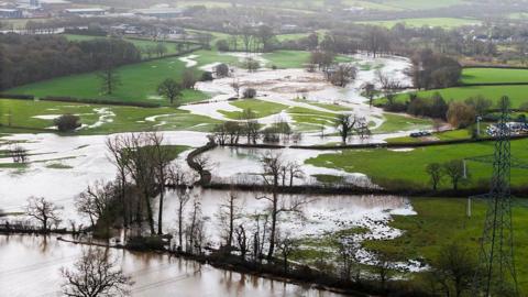 Water runs over fields after the River Otter burst its banks in East Devon