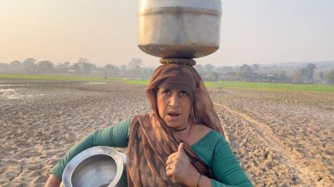 A woman stands at a farm in the Bundelkhand region of Madhya Pradesh 