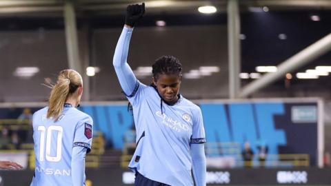 Khadija Shaw makes the 'Black Power' salute after scoring for Manchester City against Liverpool