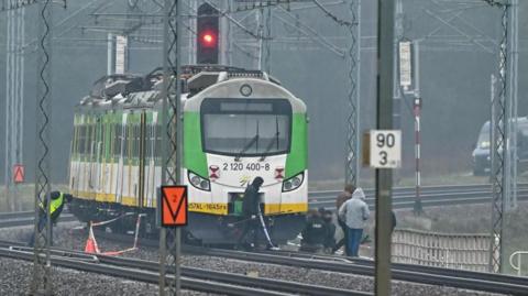 Special forces and police investigate at the scene of a destroyed section of railway tracks on the Deblin-Warsaw route near the Mika railway station, central Poland