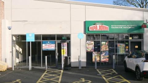 A row of two shops in Bradford. One is closed and has an under offer sign on it the neighbouring property is a pizza takeaway