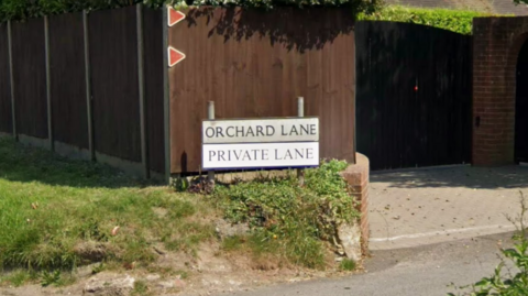 A sign outside a house saying Orchard Lane