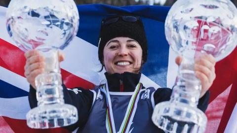 Jasmin Taylor holding two glass trophies with a medal around her neck