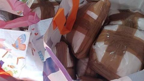 Sealed packages of suspected cocaine in a carrier bags.
